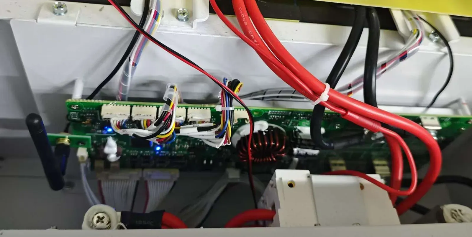 BMS control board with WiFi antenna module and wiring harness inside an energy storage battery pack